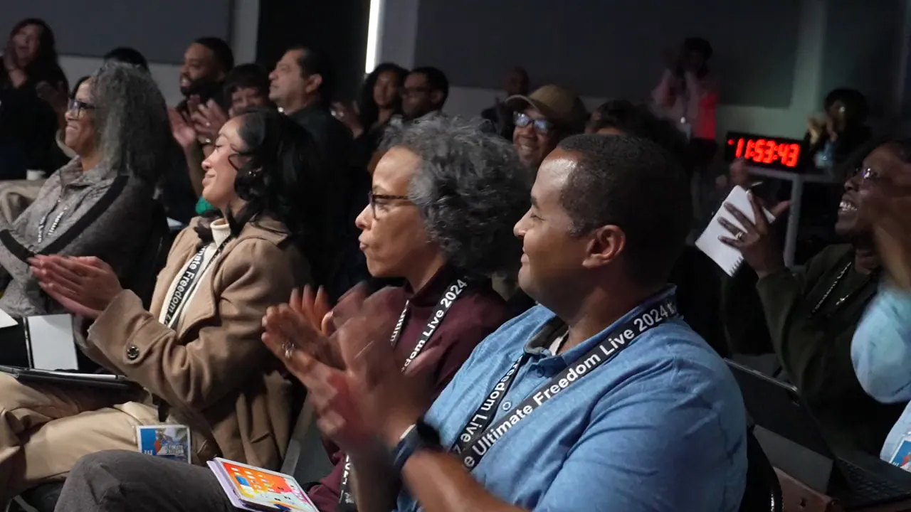 Attendees laughing and clapping at Ultimate Freedom LIVE