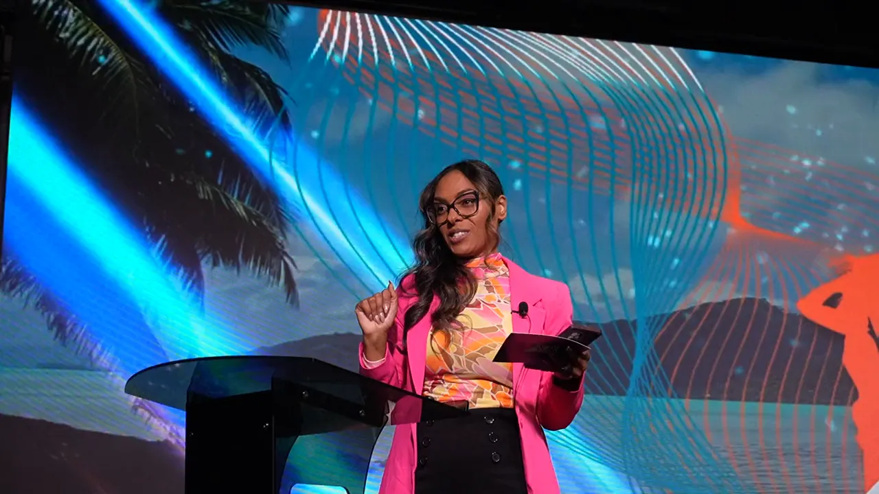 A speaker gesturing on the Ultimate Freedom LIVE stage